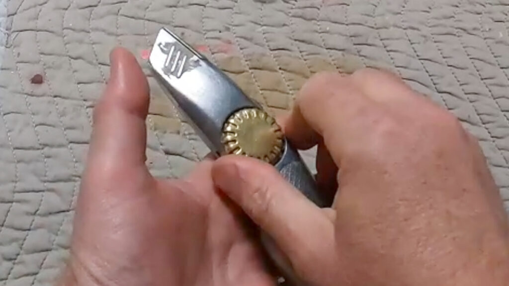 Stanley FatMax Extreme utility knife held in two hands showing thumb screw blade change mechanism